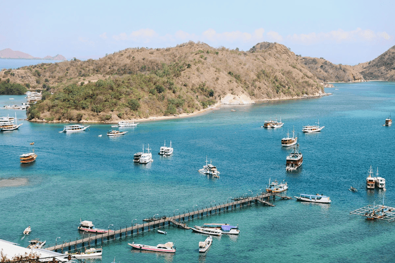 Aerial view of harbor with many boat on Labuan Bajo Island. By Garakta-Studio